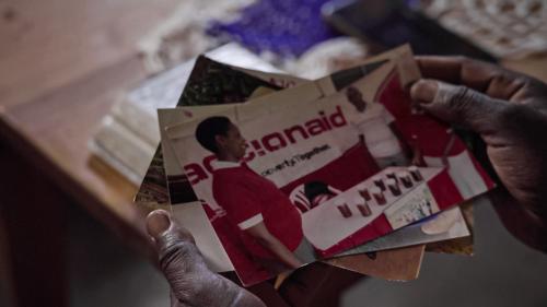 Immaculee looks through photographs of her time with ActionAid
