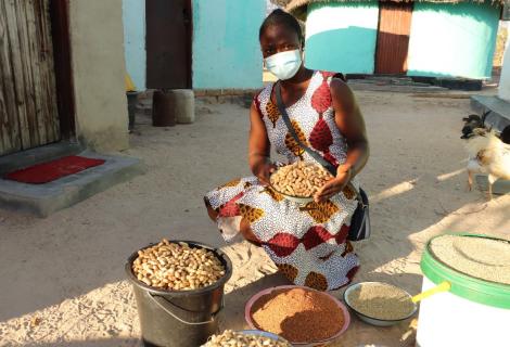 Mavis, a young smallholder farmer from Zimbabwe sits surrounded by her produce