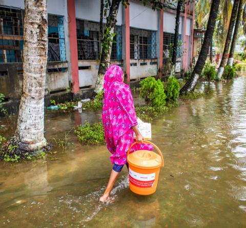 A woman collects essential relief items from an ActionAid distribution point in Noakhali Sadar District.