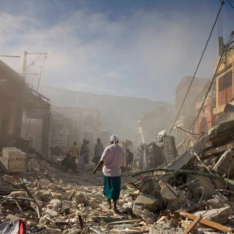 A woman walks through the rubble after the 2010 Haiti earthquake